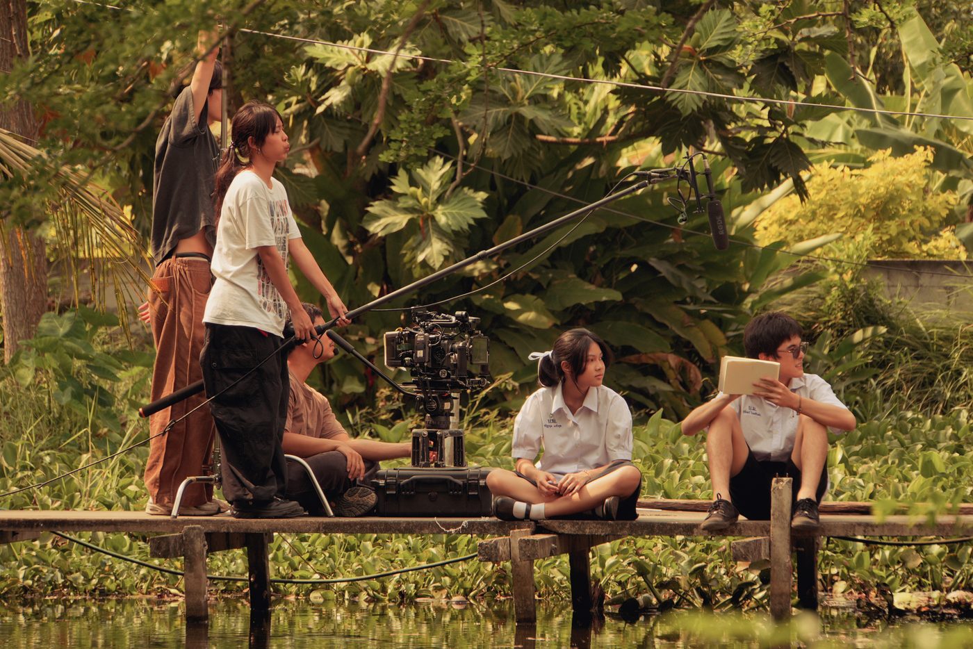 Film students on a wooden pier with a camera on a slider