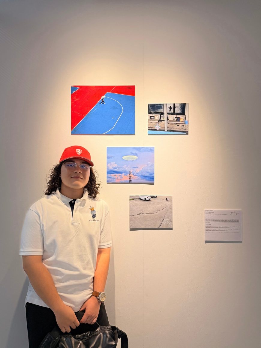 Krit standing beside his framed prints on the gallery wall