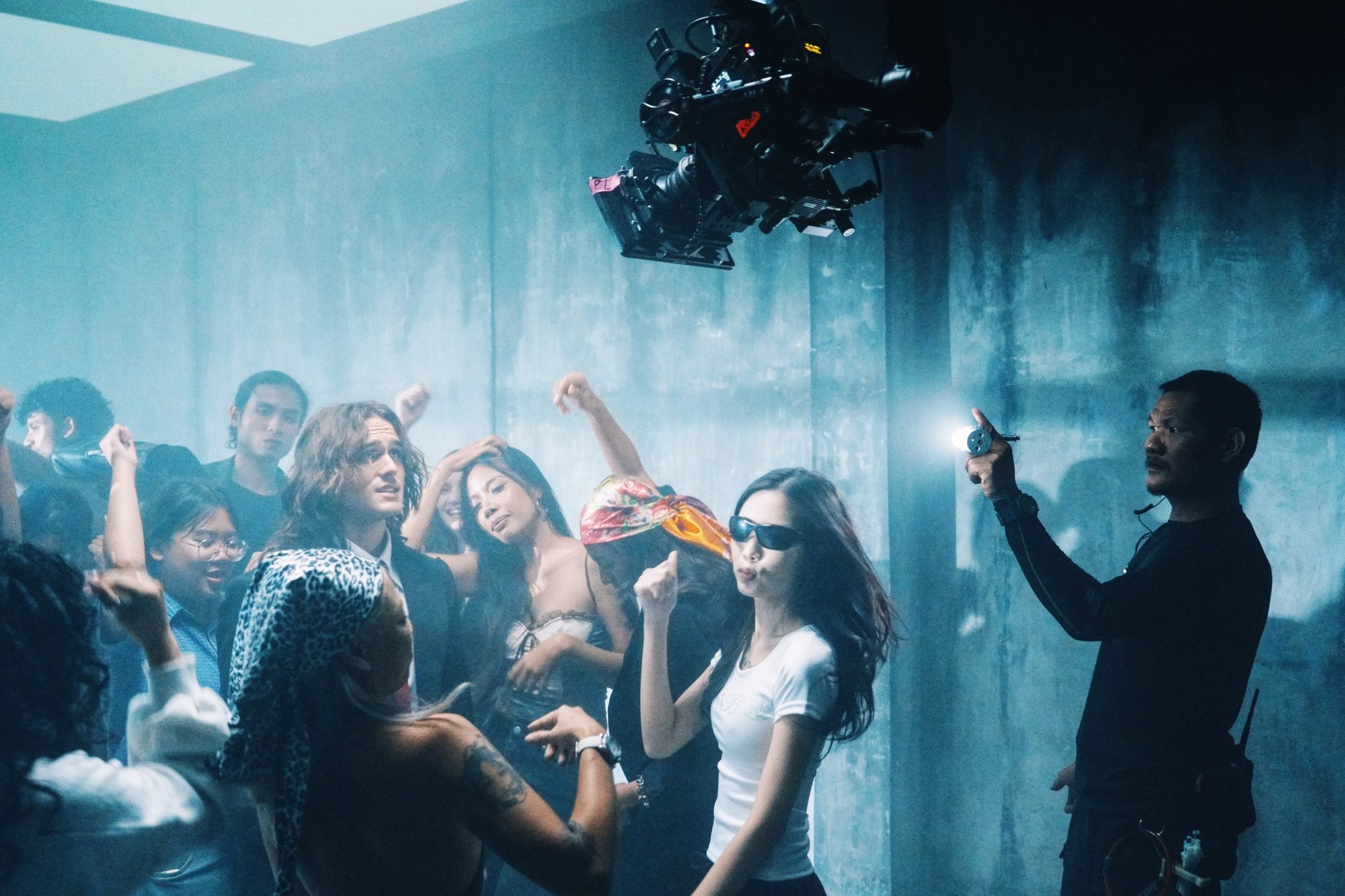 Krit on set, lighting a crowded scene with a handheld flashlight