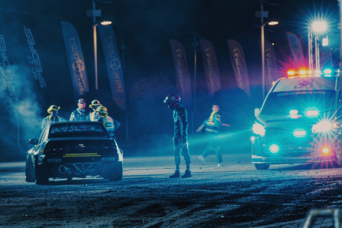 Crew and marshals in the blue haze between runs at night