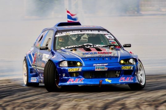 Blue Civic with the Thai flag on the roof, sliding through the corner